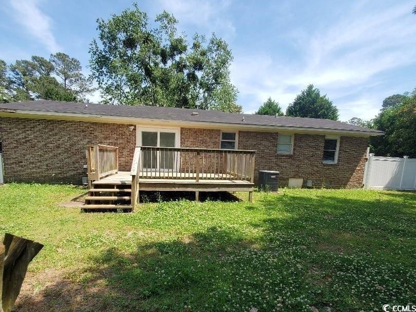 615 Burcale Rd Circle Myrtle Beach, SC 29579 - Photo 2 of 17 Rear view of property featuring brick siding, a wooden deck, a yard, and central air condition unit