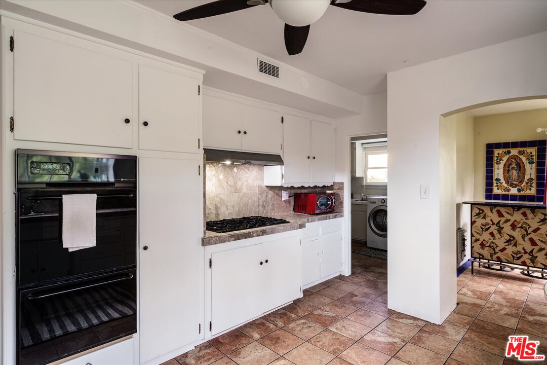 11111 Tujunga Canyon Boulevard Tujunga, CA 91042 - Photo 15 of 38 a kitchen with stainless steel appliances a refrigerator a stove and white cabinets
