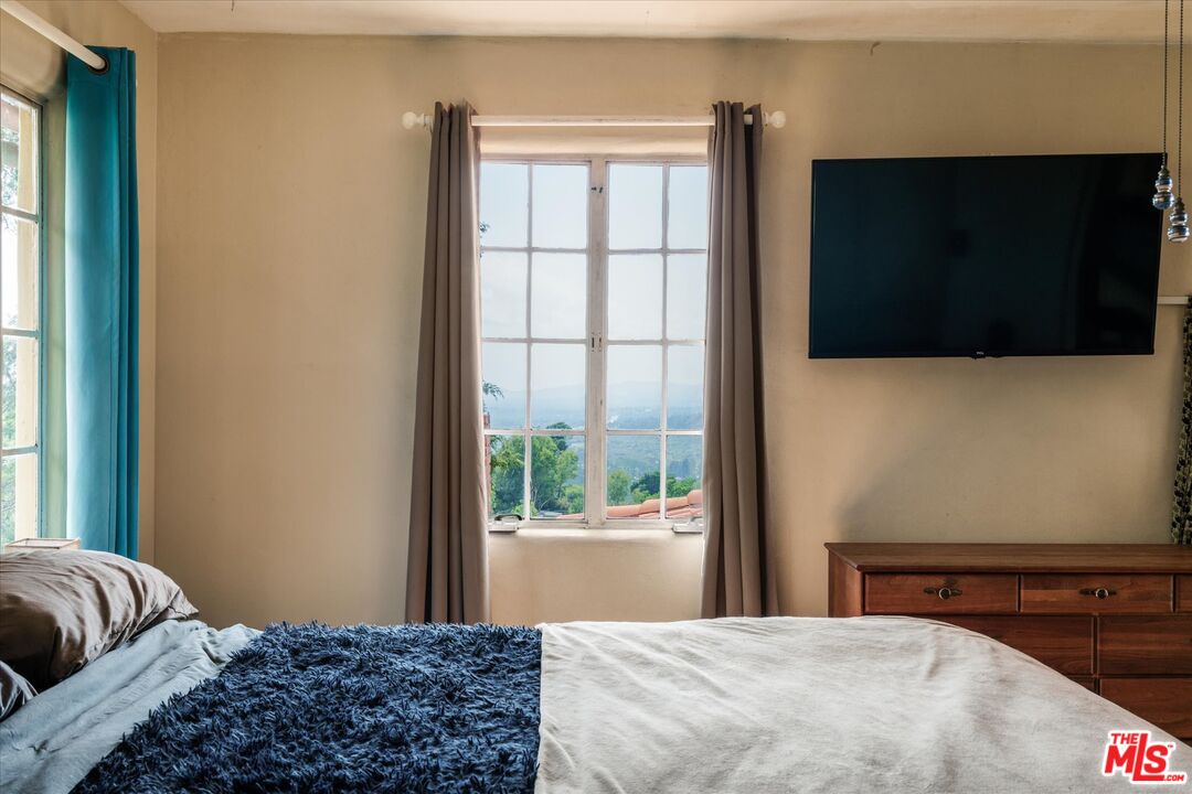 11111 Tujunga Canyon Boulevard Tujunga, CA 91042 - Photo 21 of 38 a bedroom with a bed and a flat tv screen on dresser