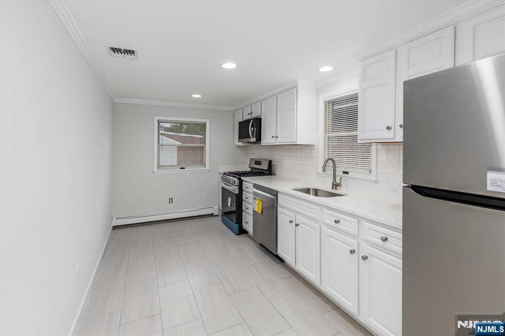 4 Coppola Street, Unit 2 Nutley, NJ 07110 - Photo 7 of 14 a kitchen with stainless steel appliances a refrigerator sink and white cabinets