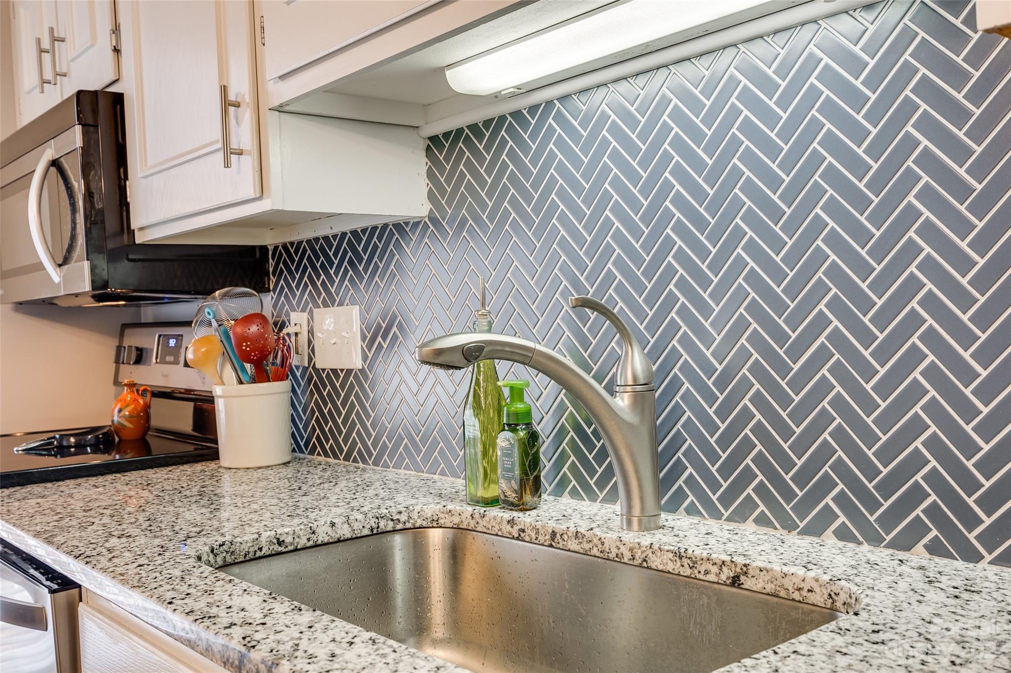 301 Queens Road, Unit 304 Charlotte, NC 28204 - Photo 6 of 26 a kitchen with a sink and a microwave