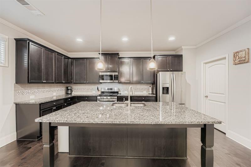 122 Prospect Lane Dallas, GA 30157 - Photo 11 of 34 a kitchen with granite countertop stainless steel appliances a sink refrigerator and microwave
