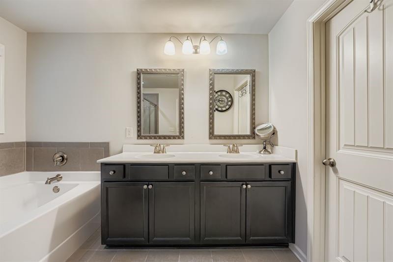 122 Prospect Lane Dallas, GA 30157 - Photo 16 of 34 a bathroom with a granite countertop sink a large mirror and a bathtub