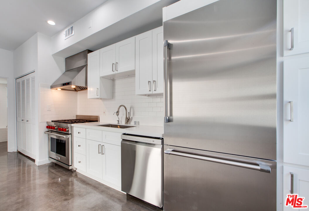 1358 4th Street, Unit PHE Santa Monica, CA 90401 - Photo 12 of 23 a kitchen with stainless steel appliances granite countertop a sink and a refrigerator
