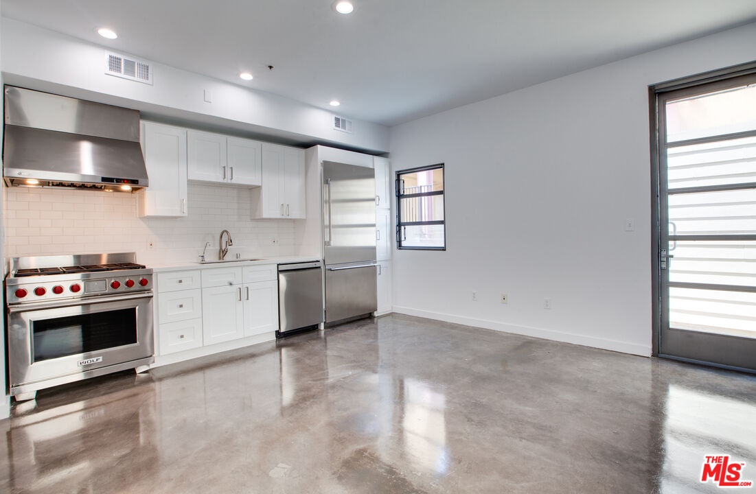 1358 4th Street, Unit PHE Santa Monica, CA 90401 - Photo 6 of 23 a kitchen with stainless steel appliances a stove sink and cabinets