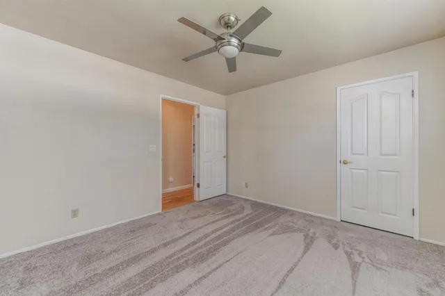 an empty room with a window and a fan