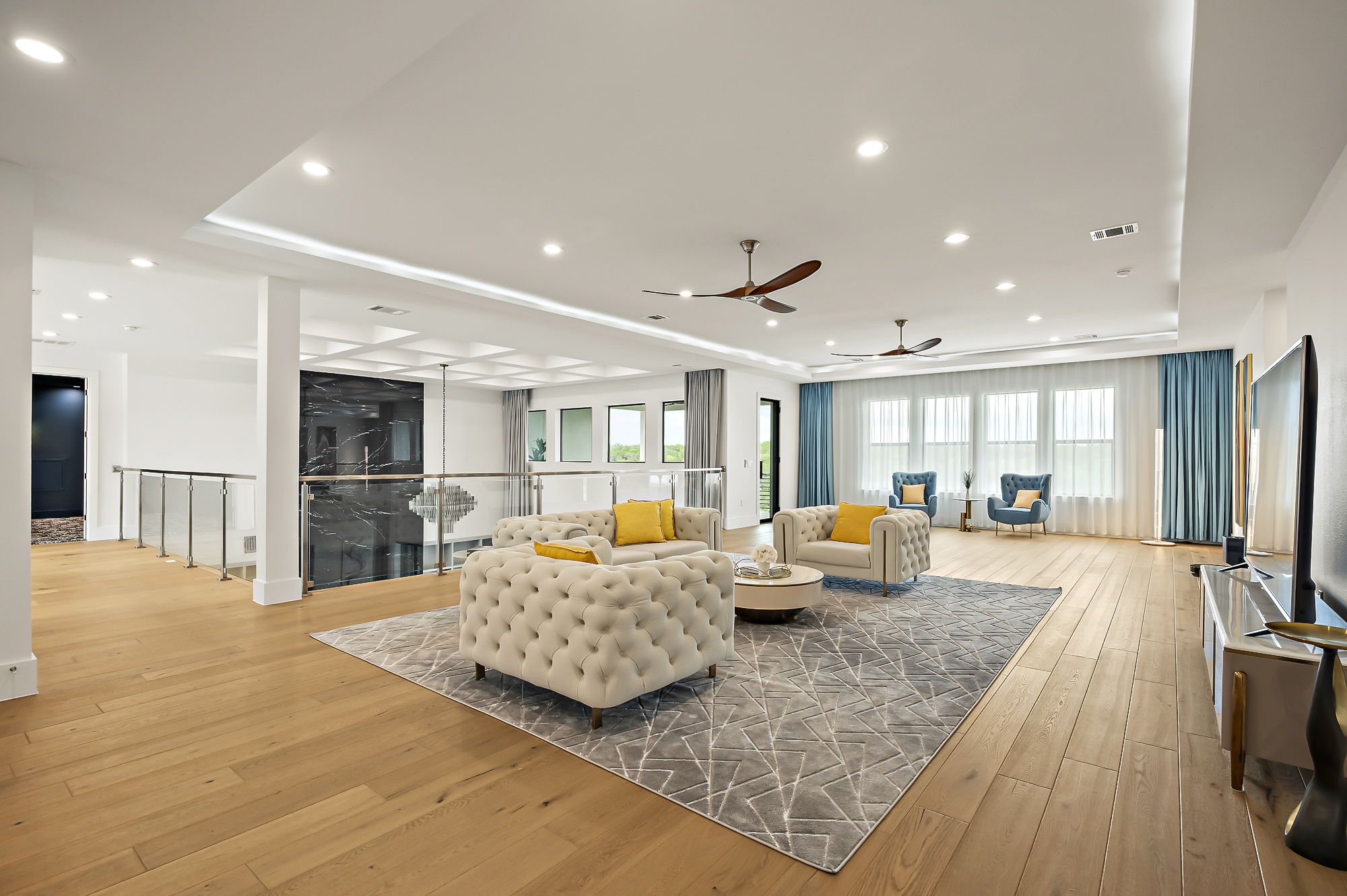 10211 Thistle Ridge Austin, TX 78733 - Photo 28 of 39 Living room with a ceiling fan, light wood-type flooring, recessed lighting, and a raised ceiling