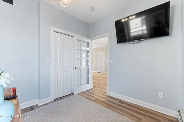 a view of a livingroom with wooden floor and flat screen tv