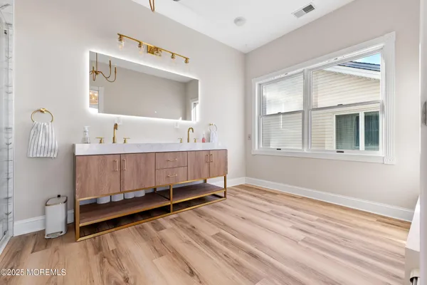 a bathroom with a shower a sink a toilet and a mirror