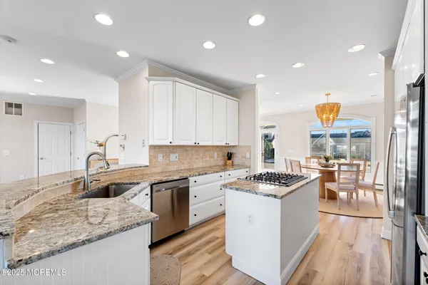 a kitchen with stainless steel appliances granite countertop a sink stove and refrigerator
