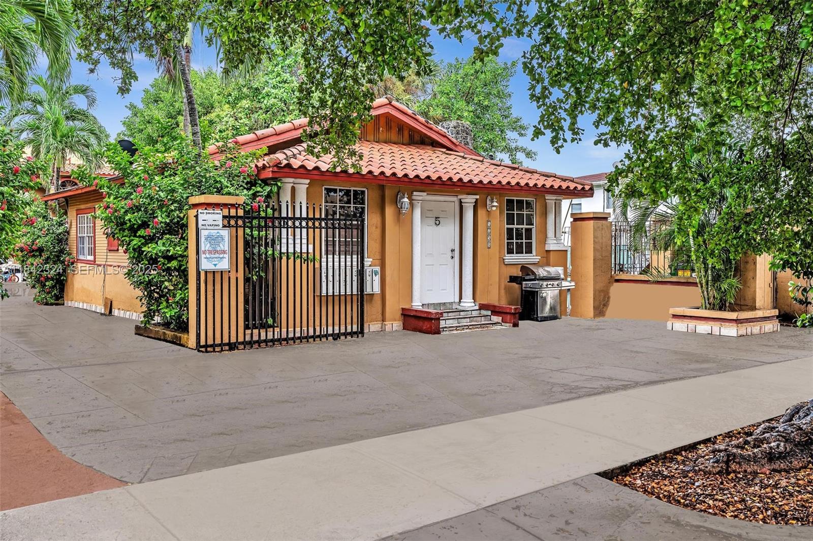 1228 Southwest 2nd Street Miami, FL 33135 - Photo 4 of 18 a view of a white house with large windows and a small yard