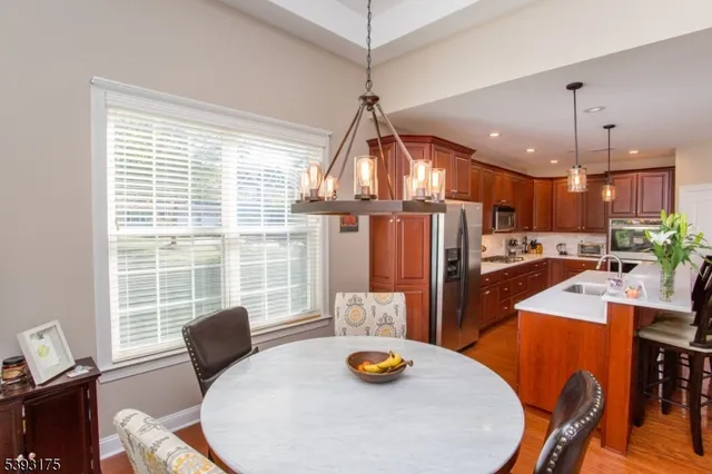 a view of a dining room and livingroom with furniture wooden floor and a chandelier