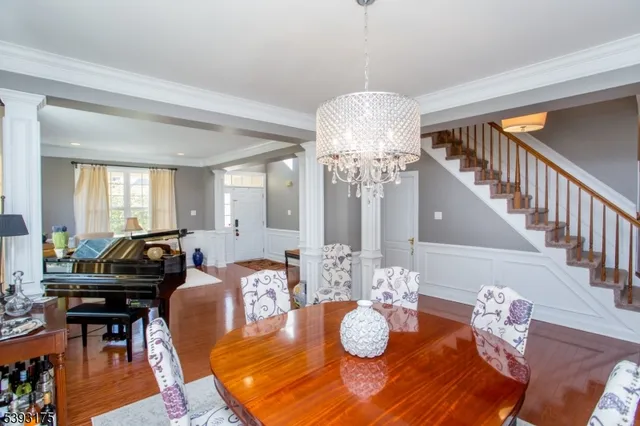 a view of a dining room with furniture a chandelier and wooden floor