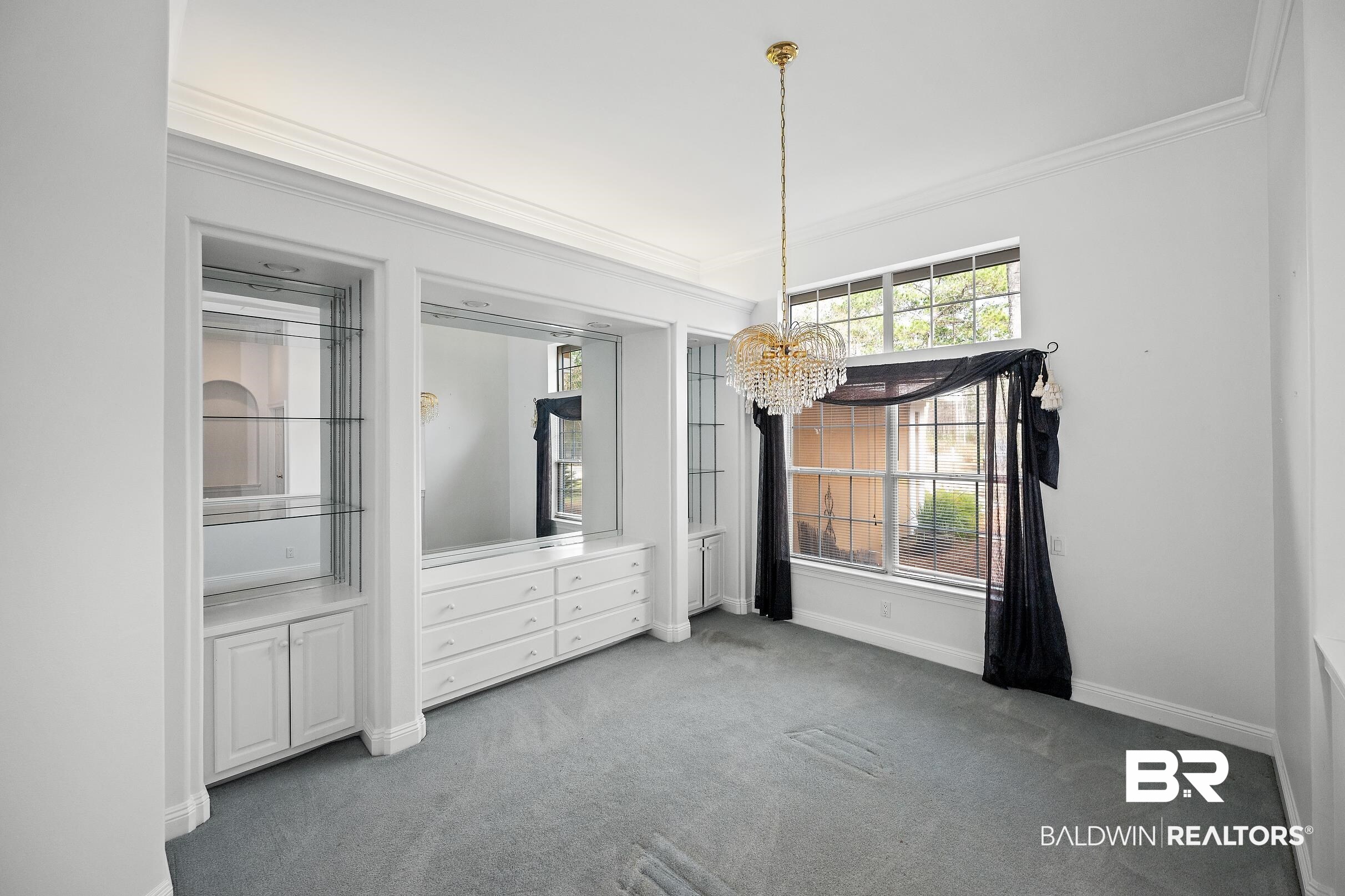 8591 Bay Harbor Road Elberta, AL 36530 - Photo 24 of 56 Unfurnished dining area featuring a chandelier, ornamental molding, and carpet