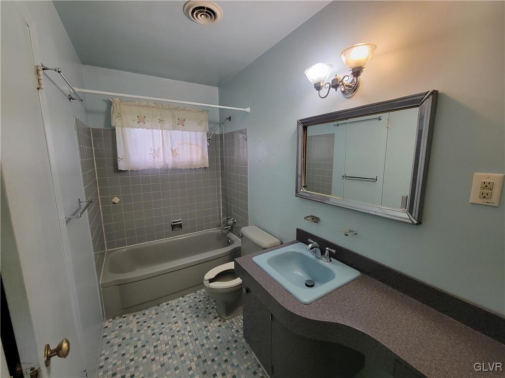 1312 5th Street Whitehall, PA 18052 - Photo 13 of 29 a bathroom with a bathtub shower sink vanity mirror and toilet