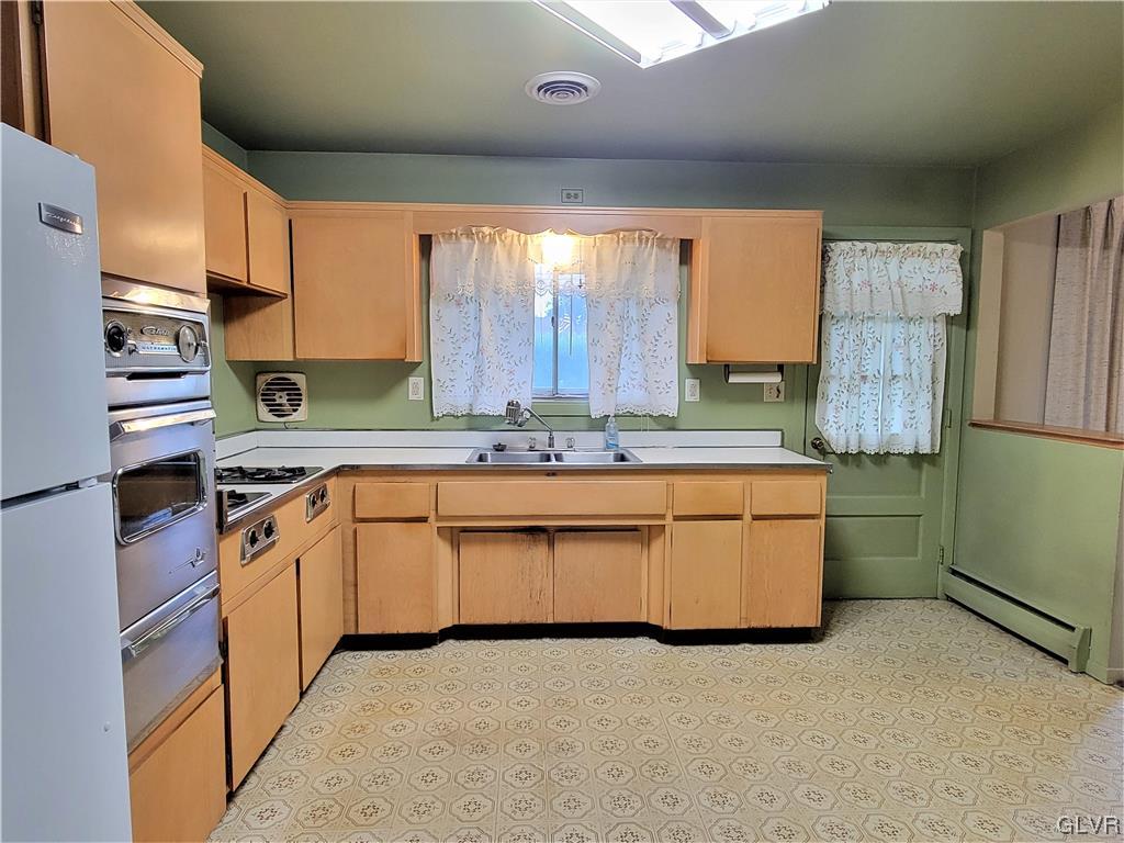 1312 5th Street Whitehall, PA 18052 - Photo 4 of 29 a kitchen with stainless steel appliances granite countertop a sink and a refrigerator