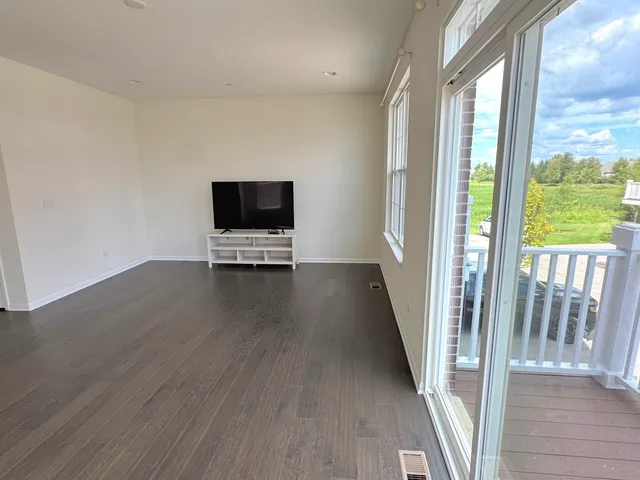 a view of a livingroom with wooden floor and a floor to ceiling window