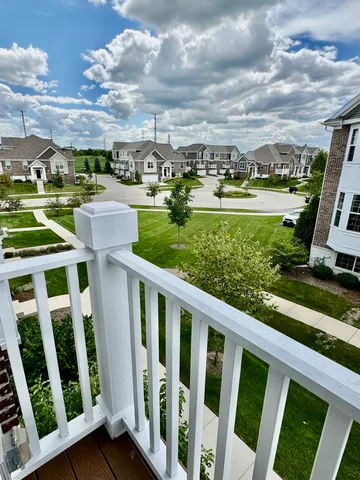 a view of a swimming pool with lawn chairs and wooden fence