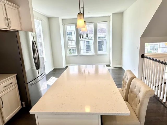 a large white bed sitting in a kitchen next to a window