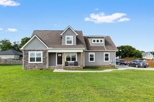 a front view of a house with a garden and trees