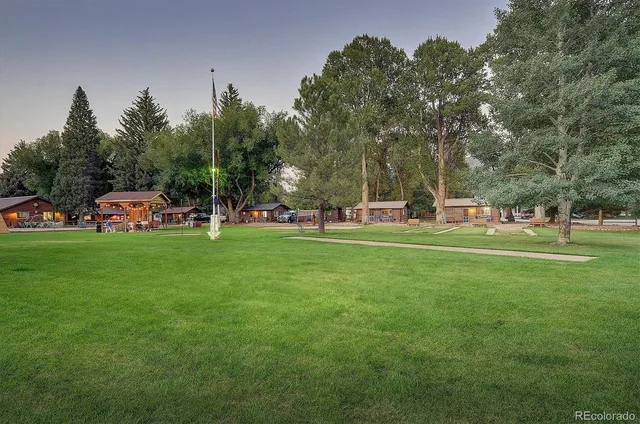 a front view of a house with a yard and trees