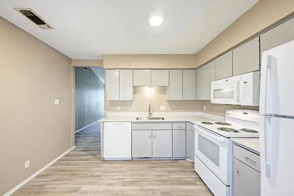 a kitchen with stainless steel appliances a sink a stove a refrigerator and cabinets