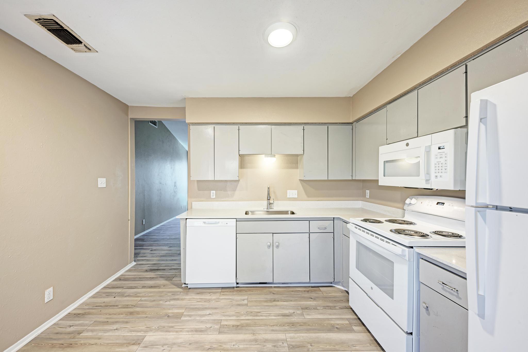 1117 West Rundberg Lane, Unit A Austin, TX 78758 - Photo 12 of 31 Kitchen featuring white appliances, light countertops, and light wood-style floors