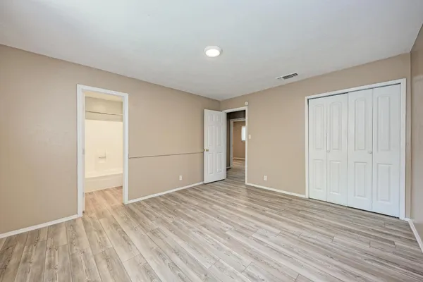 a view of an empty room with wooden floor