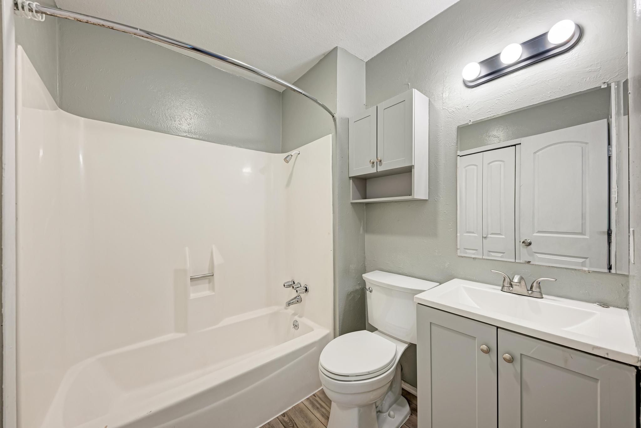 1117 West Rundberg Lane, Unit A Austin, TX 78758 - Photo 18 of 31 Bathroom with vanity, shower combination, a textured wall, wood finished floors, and a closet