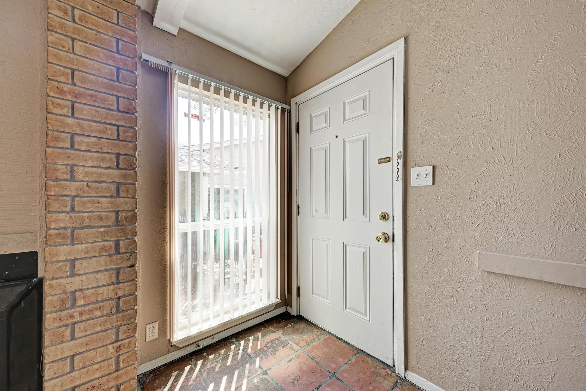 1117 West Rundberg Lane, Unit A Austin, TX 78758 - Photo 3 of 31 Foyer featuring a textured wall and vaulted ceiling