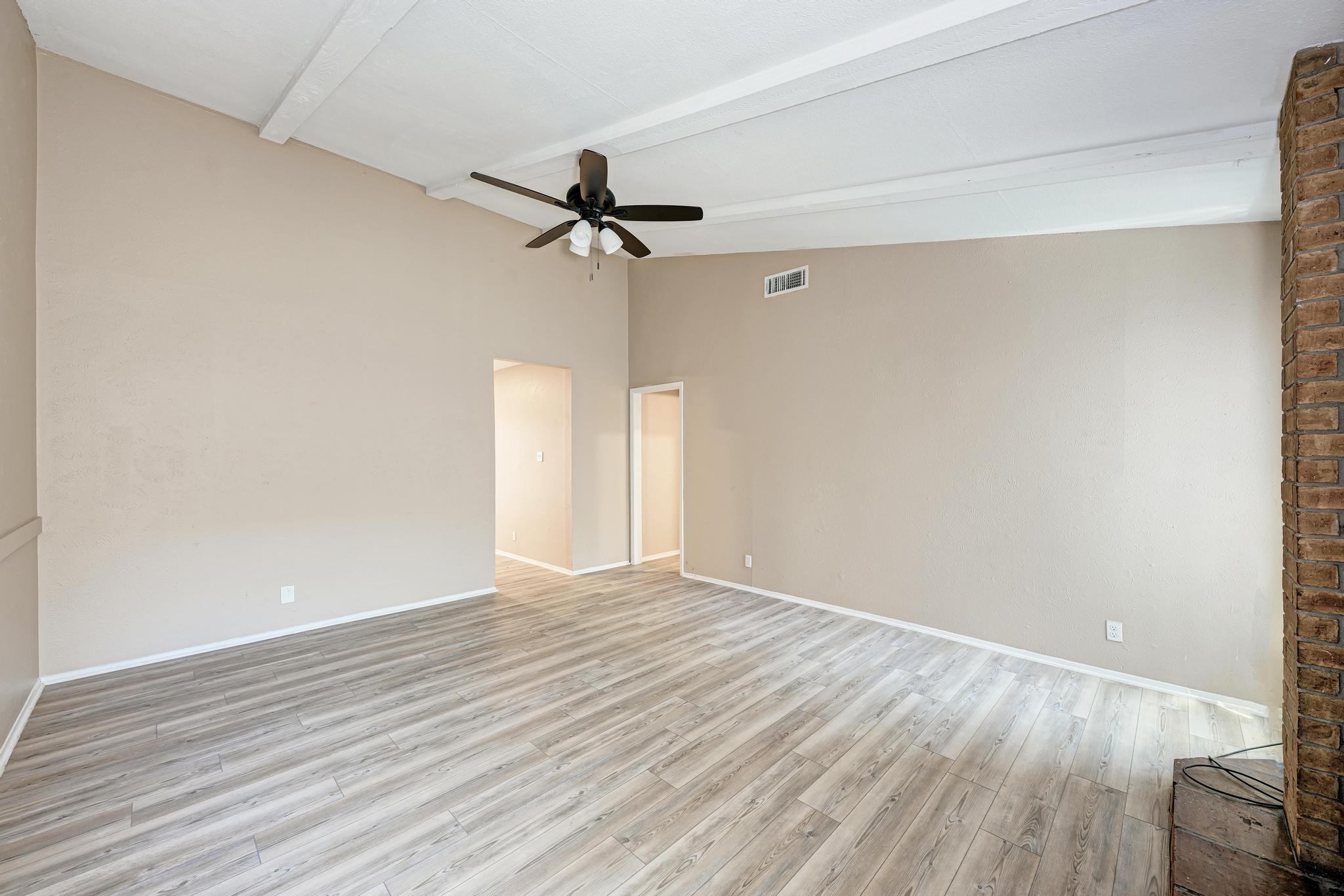 1117 West Rundberg Lane, Unit A Austin, TX 78758 - Photo 4 of 31 Empty room with lofted ceiling, light wood-type flooring, and ceiling fan