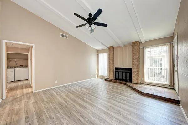 a view of empty room with wooden floor and fireplace