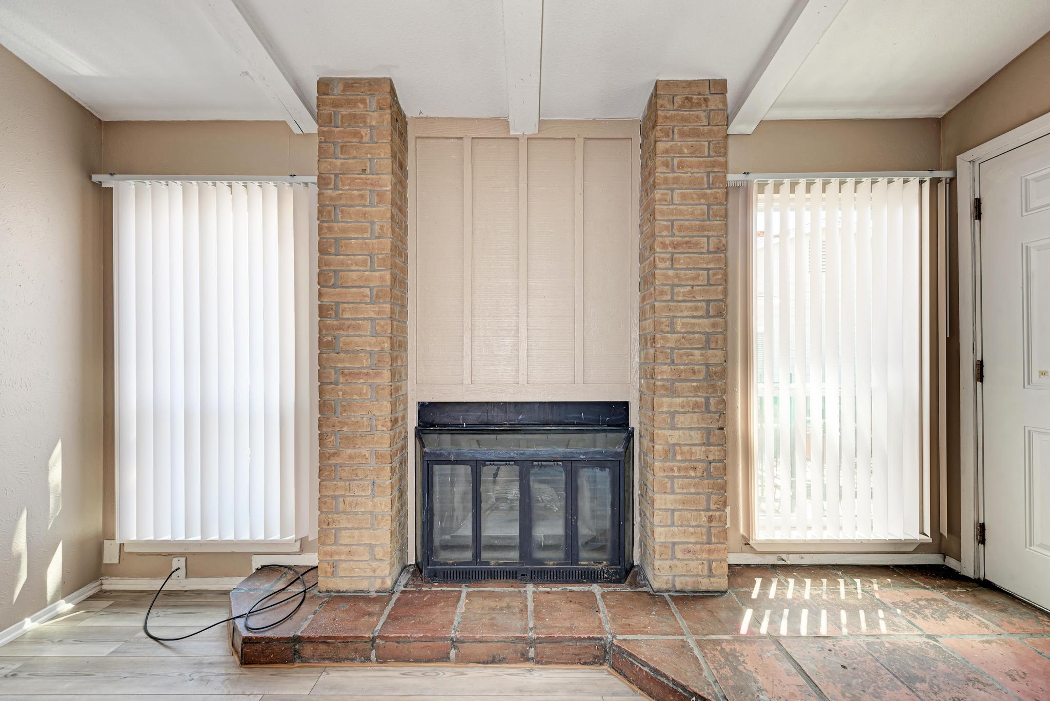 1117 West Rundberg Lane, Unit A Austin, TX 78758 - Photo 8 of 31 Unfurnished living room featuring a fireplace and beam ceiling