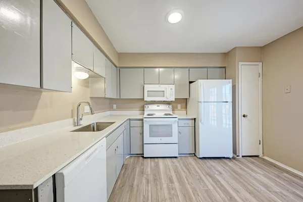 a kitchen with a sink cabinets stainless steel appliances and a window