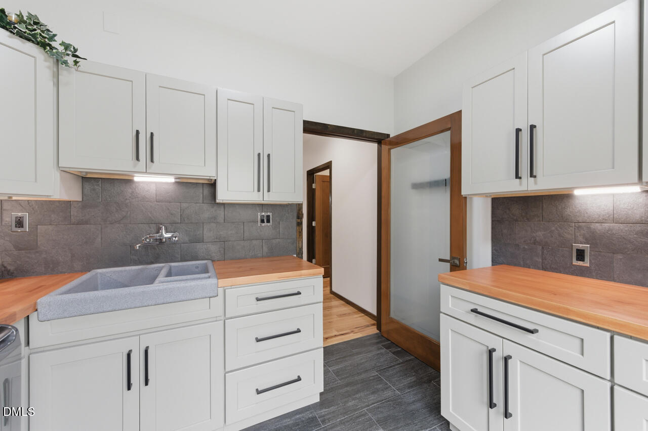 3315 Denada Path Durham, NC 27707 - Photo 53 of 74 a kitchen with white cabinets and refrigerator