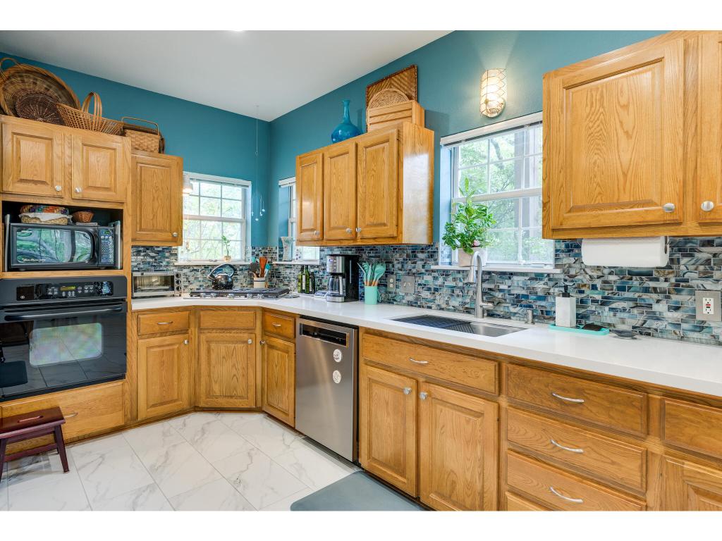 1602 Wild Basin Ledge Austin, TX 78746 - Photo 13 of 40 a kitchen with granite countertop stainless steel appliances a sink window and cabinets