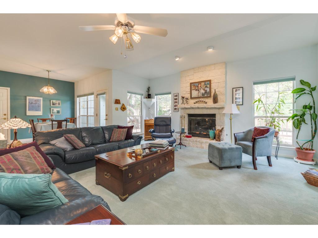 1602 Wild Basin Ledge Austin, TX 78746 - Photo 6 of 40 a living room with furniture a fireplace and a chandelier