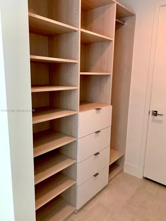a view of walk in closet with empty racks