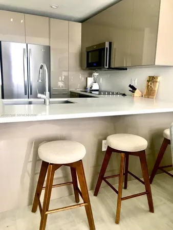 a kitchen with a sink a microwave a refrigerator and cabinets