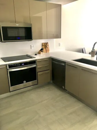a kitchen with a sink and a stove top oven with wooden floor