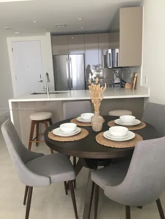 a kitchen with a table chairs stove and white cabinets