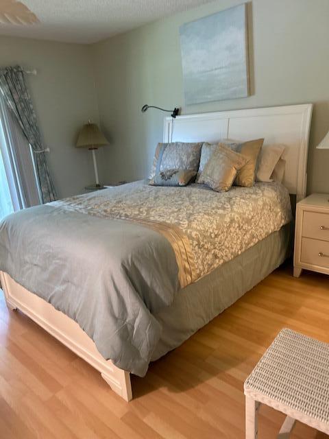 1955 Southwest Palm City Road, Unit H Stuart, FL 34994 - Photo 16 of 22 a bedroom with a bed and a night stand