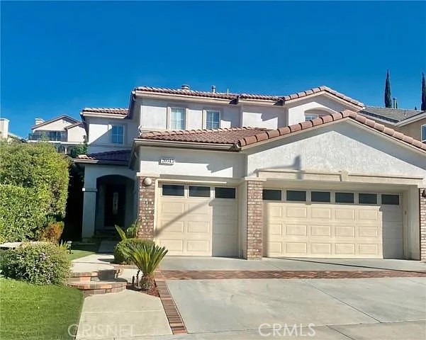 20543 Pesaro Porter Ranch Porter Ranch, CA 91326 - Photo 1 of 67 a front view of a house with a garden and plants
