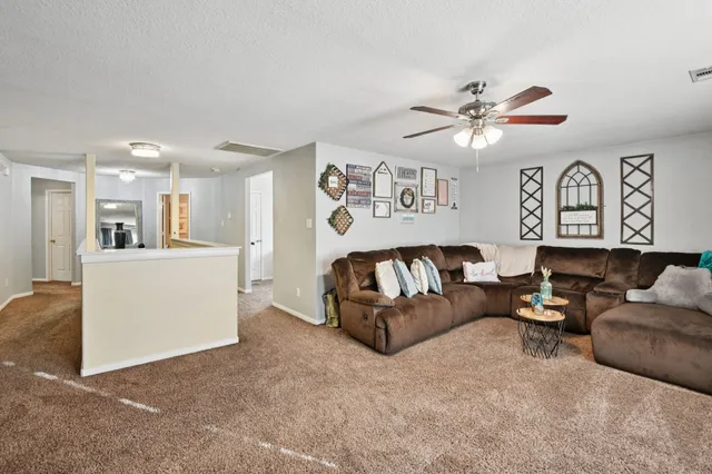 a living room with furniture and kitchen view