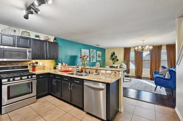 a kitchen with a stove sink and cabinets