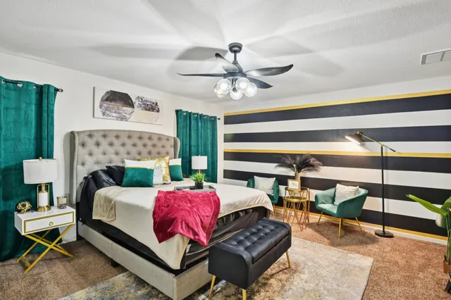 a bedroom with a bed a lamp and a fireplace