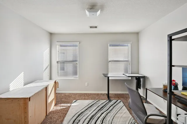 a bedroom with a bed and a desk in it