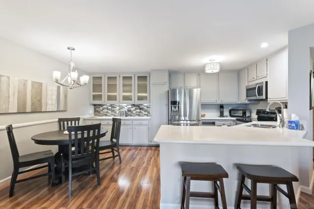 a kitchen with kitchen island a dining table and chairs