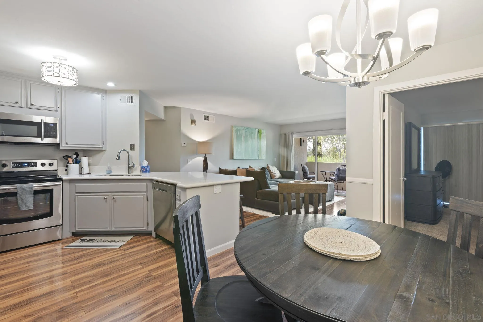 17617 Pomerado Road, Unit 112 San Diego, CA 92128 - Photo 6 of 26 a kitchen with stainless steel appliances granite countertop a kitchen island a stove a table and chairs in it