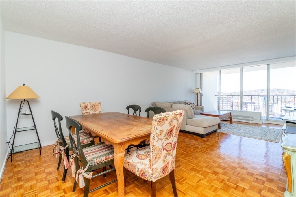 33 Pond Avenue, Unit 1106 Brookline, MA 02445 - Photo 11 of 32 a view of a dining room with furniture a chandelier and wooden floor